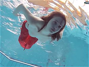 red clad teenager swimming with her eyes opened